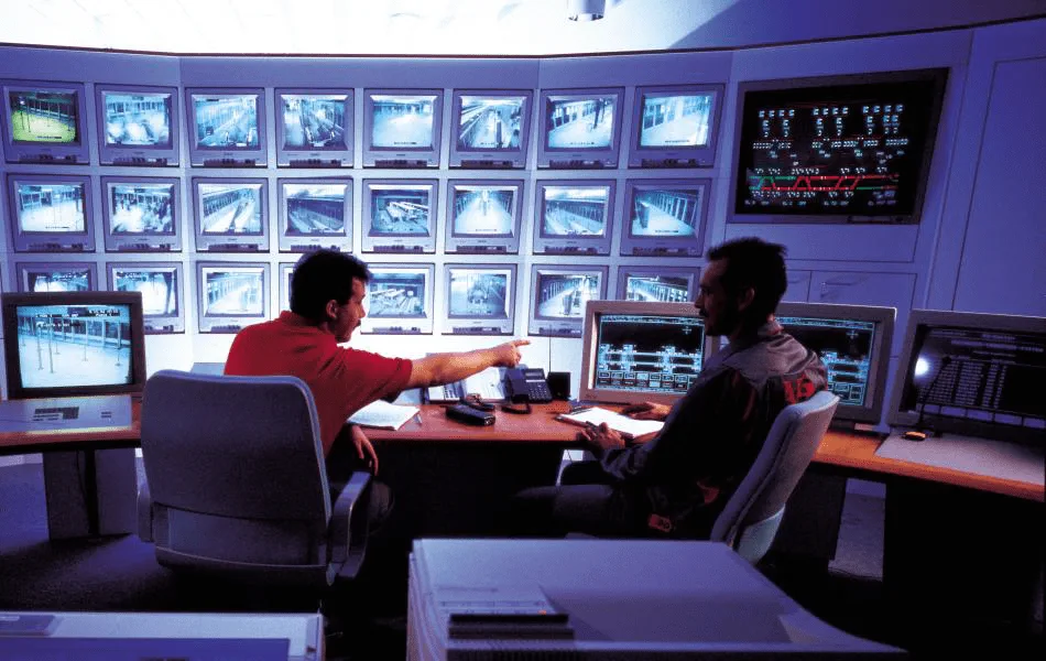 Kontrollzentrum mit Mitarbeitern vor Monitoren die Zugdaten überwachen.