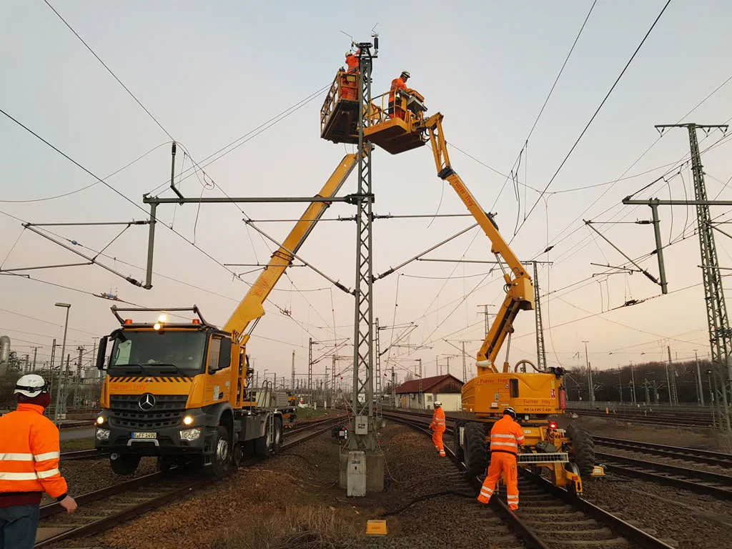 Bauarbeiten an Oberleitungen mit Einsatz von Kränen und Spezialfahrzeugen.