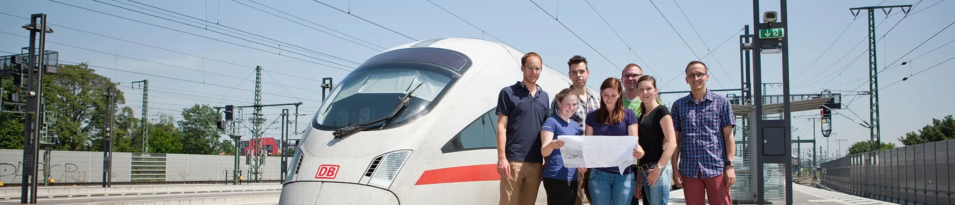 Studierende in Warnwesten stehen neben einem Zug auf dem FH Erfurt Campus.